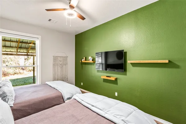 a bedroom with a bed and a flat screen tv