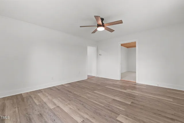 a view of empty room with wooden floor