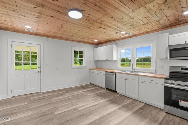 a large kitchen with a window and stainless steel appliances