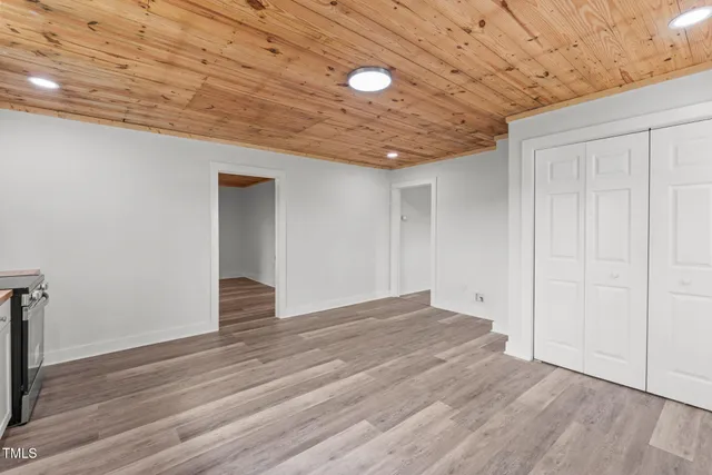 a view of an empty room with wooden floor