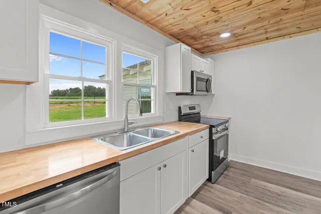 a kitchen that has a sink and a wooden floor