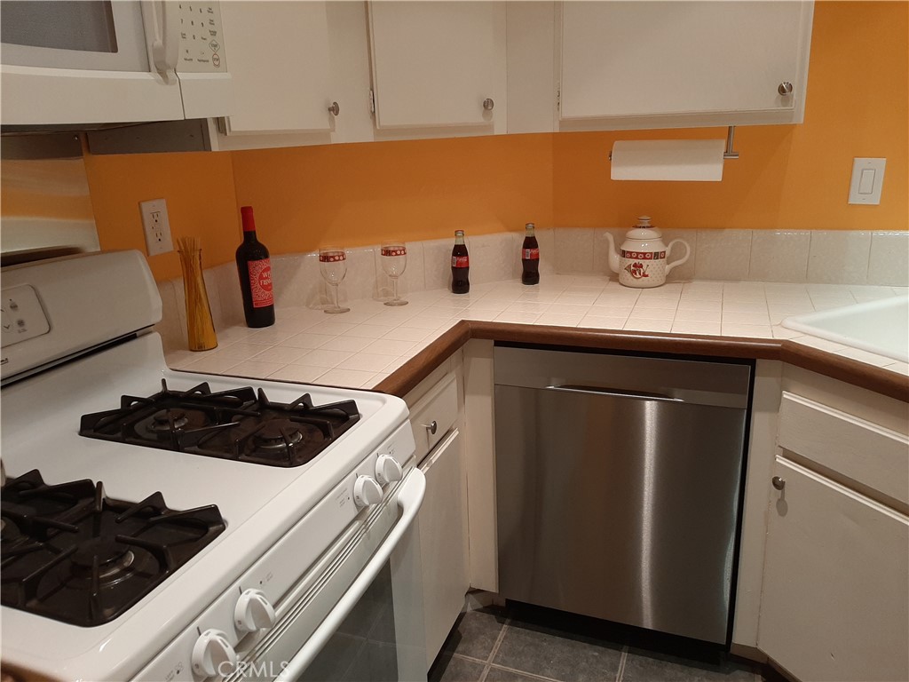 12592 Montecito Road, Unit 9 Seal Beach, CA 90740 - Photo 33 of 34 a kitchen with a sink and wooden cabinets