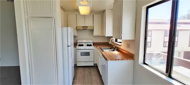 a kitchen with white cabinets and white appliances