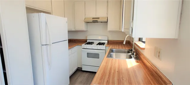 a kitchen with white cabinets and white appliances