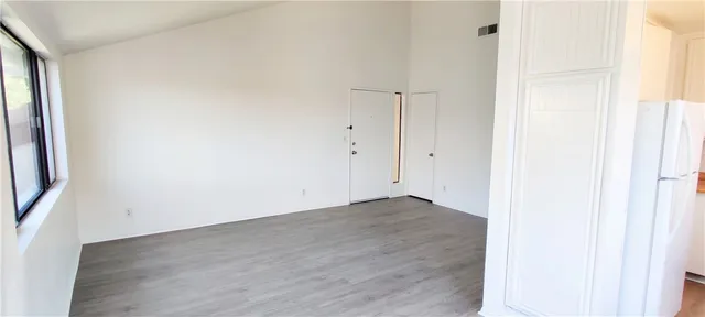 an empty room with wooden floor and mirror