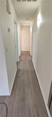 a view of a hallway with wooden floor