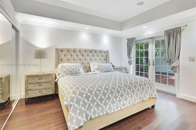 a bedroom with a large bed and a wooden floor