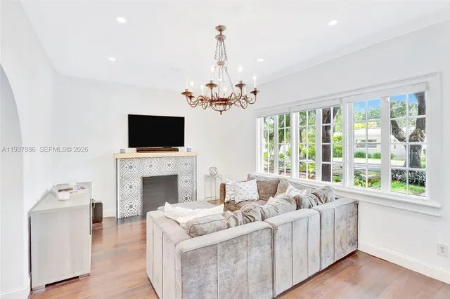 a living room with furniture a fireplace and a chandelier