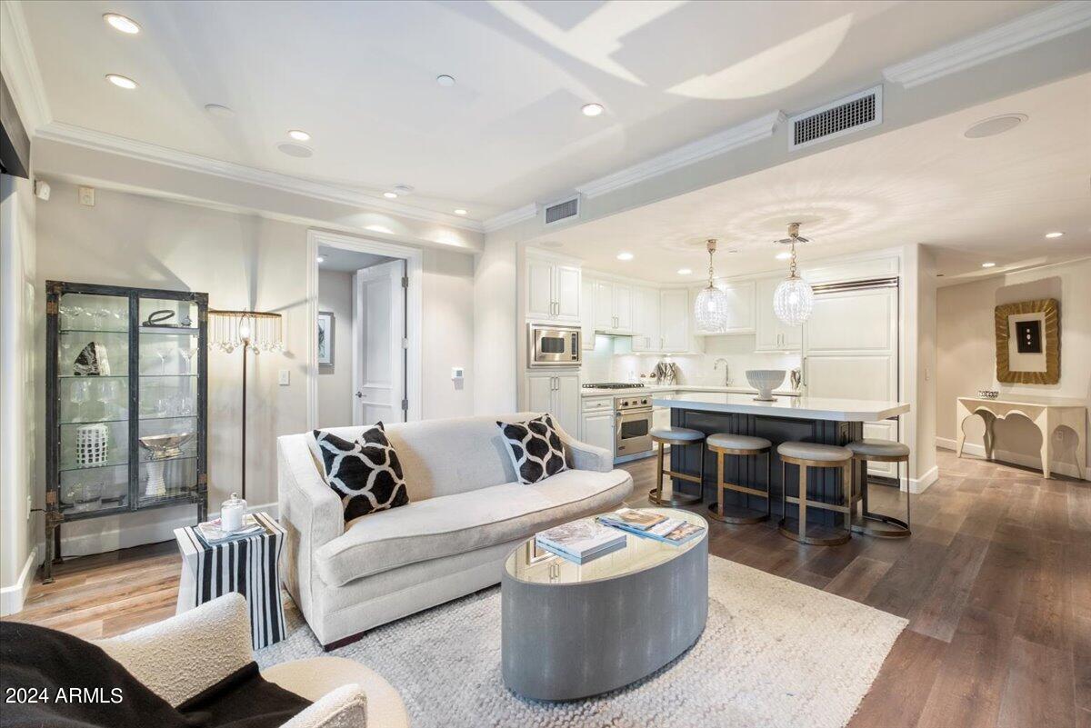 a living room with furniture and a dining table with wooden floor
