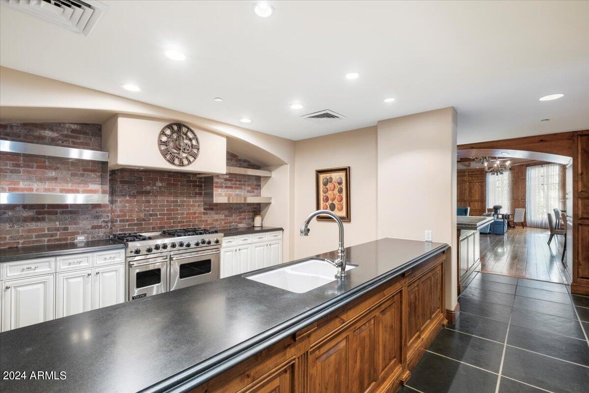 7175 East Camelback Road, Unit 107 Scottsdale, AZ 85251 - Photo 24 of 33 a kitchen with stainless steel appliances granite countertop a sink stove and refrigerator