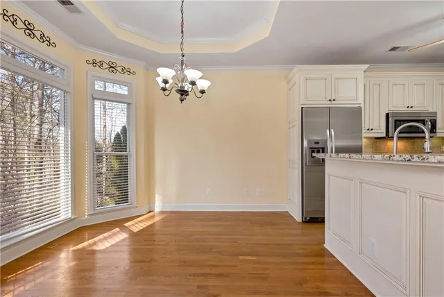 a kitchen with stainless steel appliances granite countertop a sink and cabinets with wooden floor