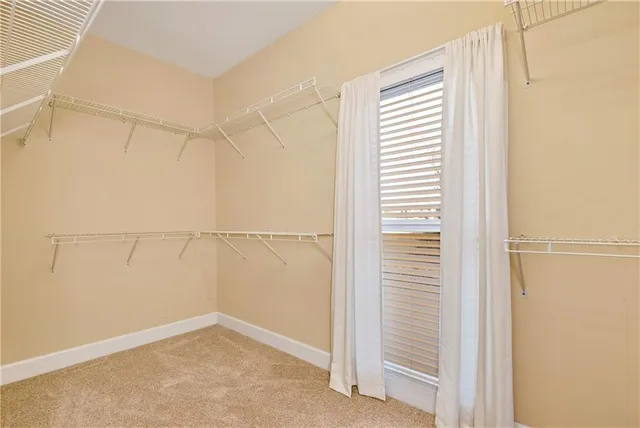 an empty room with closet and a chandelier fan