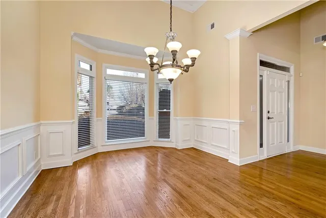 a view of an empty room with wooden floor fireplace and a window