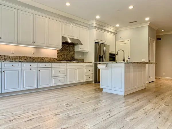 a kitchen with stainless steel appliances granite countertop a stove a sink and a refrigerator