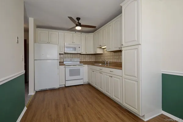 a kitchen with white cabinets stainless steel appliances and a refrigerator