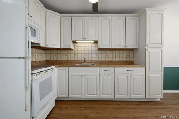 a kitchen with white cabinets and white appliances