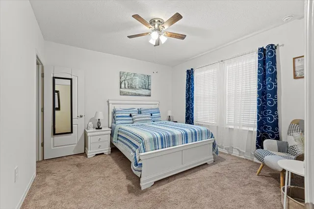 a bed sitting in a bedroom next to a window and a chandelier