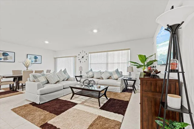 a living room with furniture a couch and a potted plant