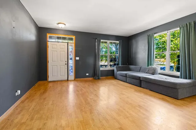 a kitchen with stainless steel appliances granite countertop a refrigerator a sink dishwasher a stove and a dining table with wooden floor