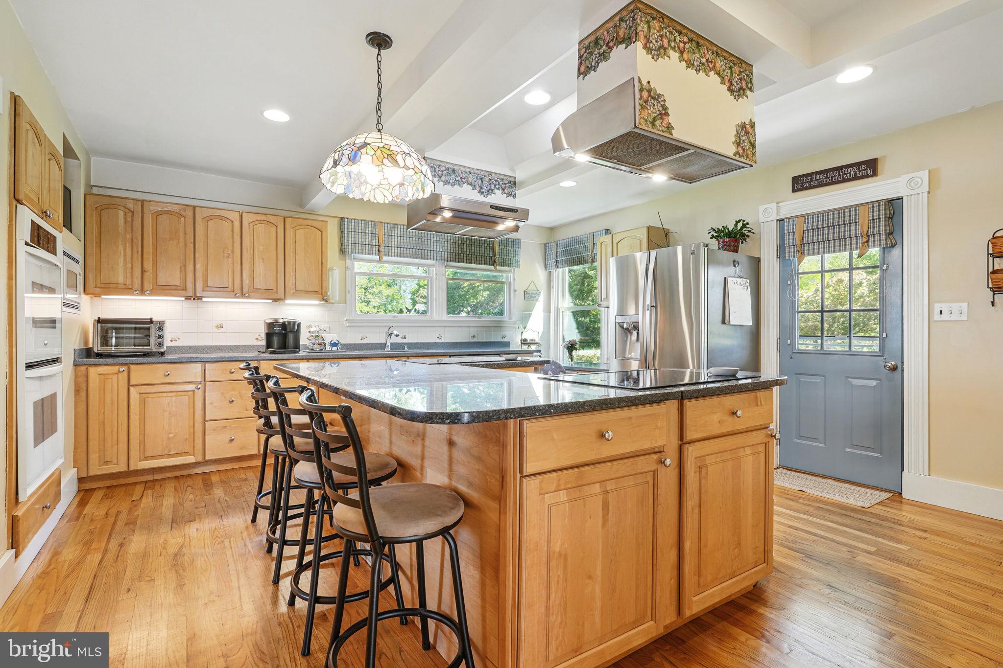 5365 Buena Vista Road Prince Frederick, MD 20678 - Photo 53 of 74 a kitchen with stainless steel appliances granite countertop wooden floors refrigerator and dining table