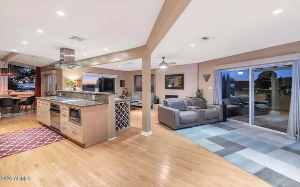 a large white open kitchen with stainless steel appliances granite countertop a stove and a sink