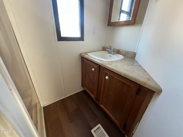 a bathroom with a granite countertop sink and a mirror
