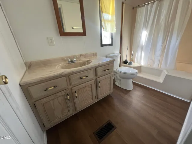 a bathroom with a double vanity sink a toilet and a tub