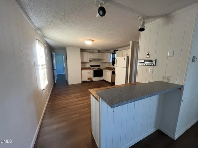 a kitchen with kitchen island a sink counter top space and appliances