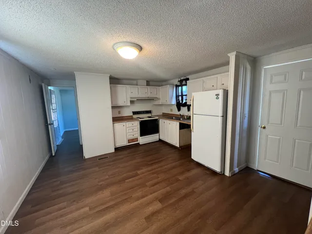a kitchen with wooden floors and white appliances