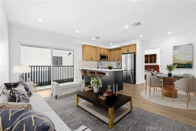 a living room with furniture kitchen view and a large window