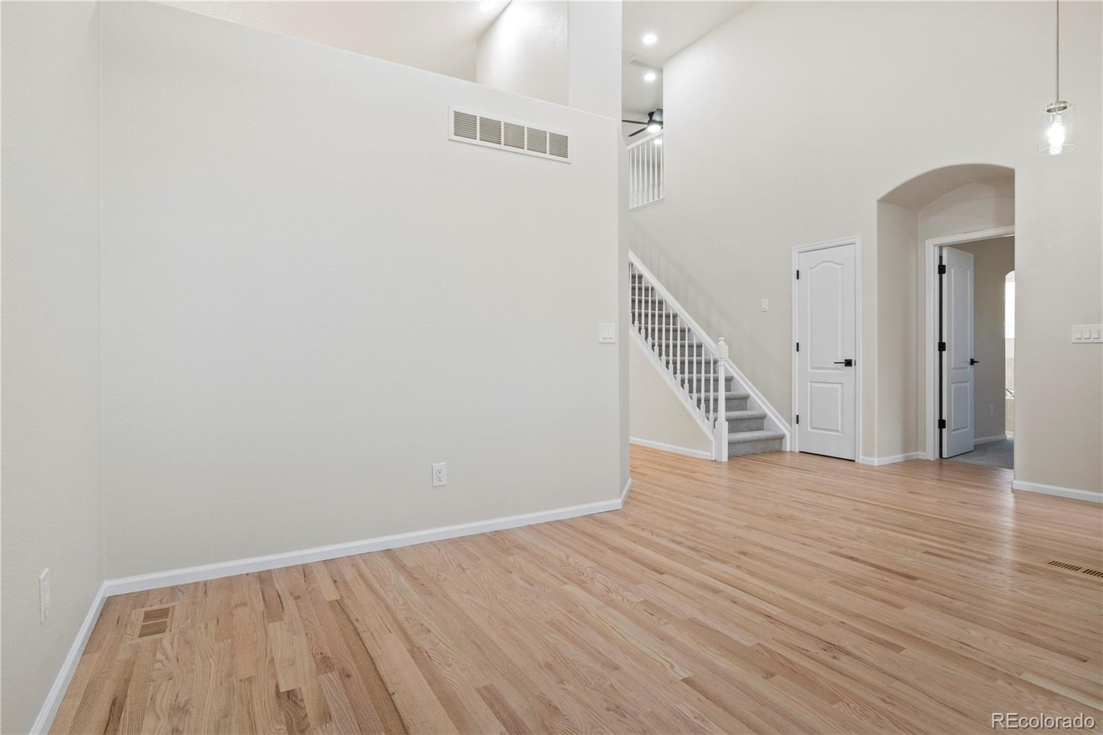 6900 West Grant Ranch Boulevard, Unit 53 Littleton, CO 80123 - Photo 11 of 31 a view of an empty room with wooden floor and stairs