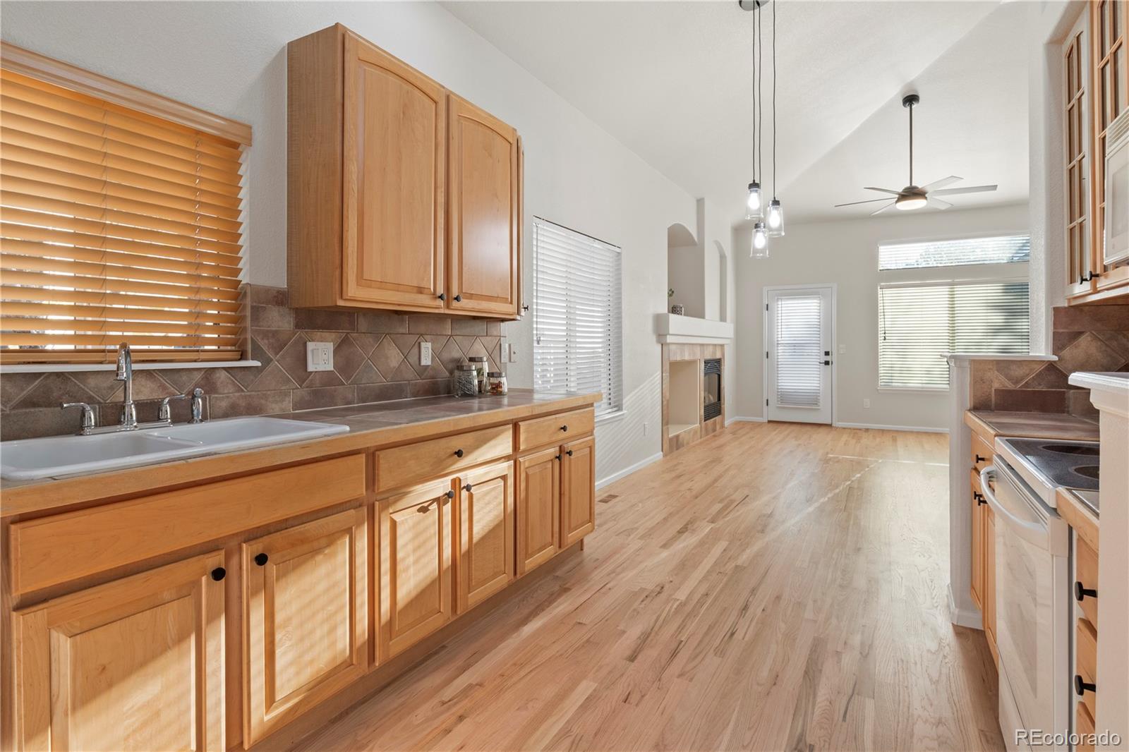 6900 West Grant Ranch Boulevard, Unit 53 Littleton, CO 80123 - Photo 14 of 31 a kitchen with stainless steel appliances granite countertop hardwood floor sink stove and wooden cabinets