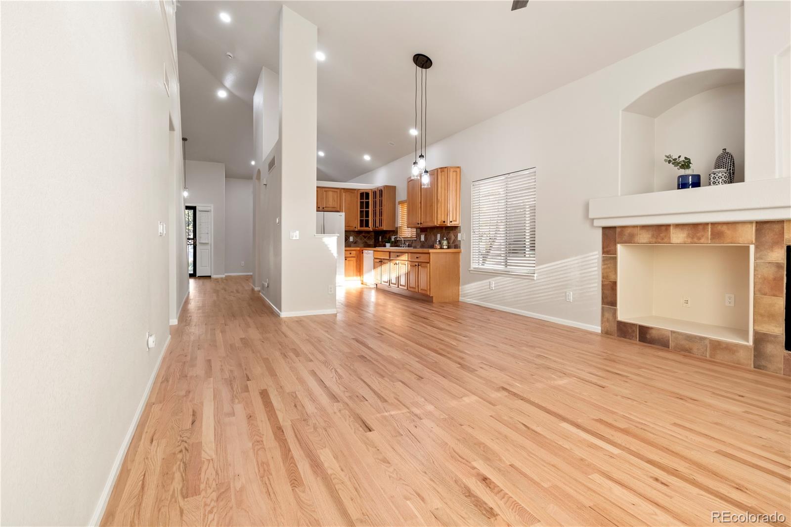 6900 West Grant Ranch Boulevard, Unit 53 Littleton, CO 80123 - Photo 16 of 31 a view of a living room and kitchen with furniture wooden floor and a chandelier