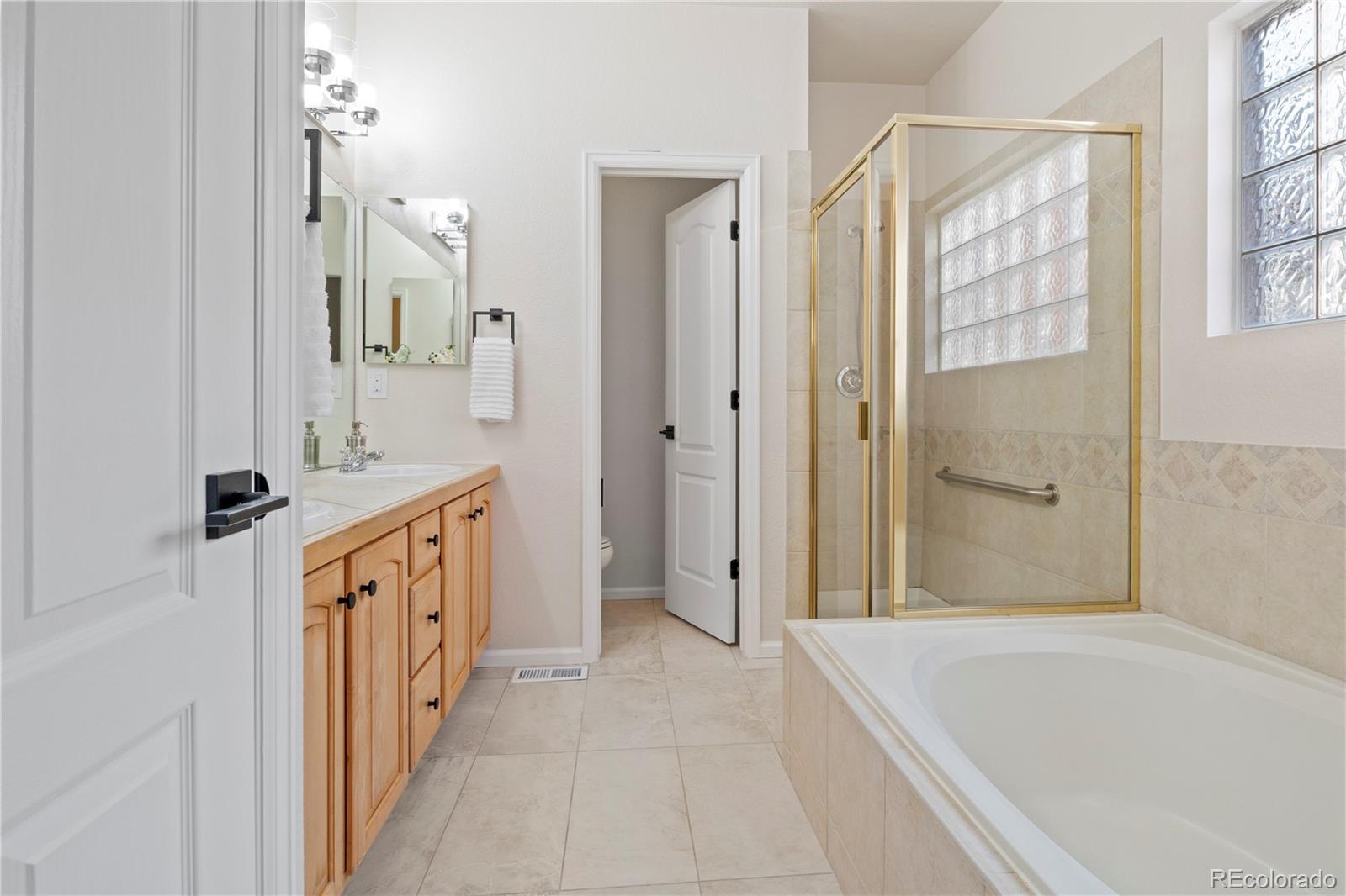 6900 West Grant Ranch Boulevard, Unit 53 Littleton, CO 80123 - Photo 19 of 31 a spacious bathroom with a tub sink and mirror