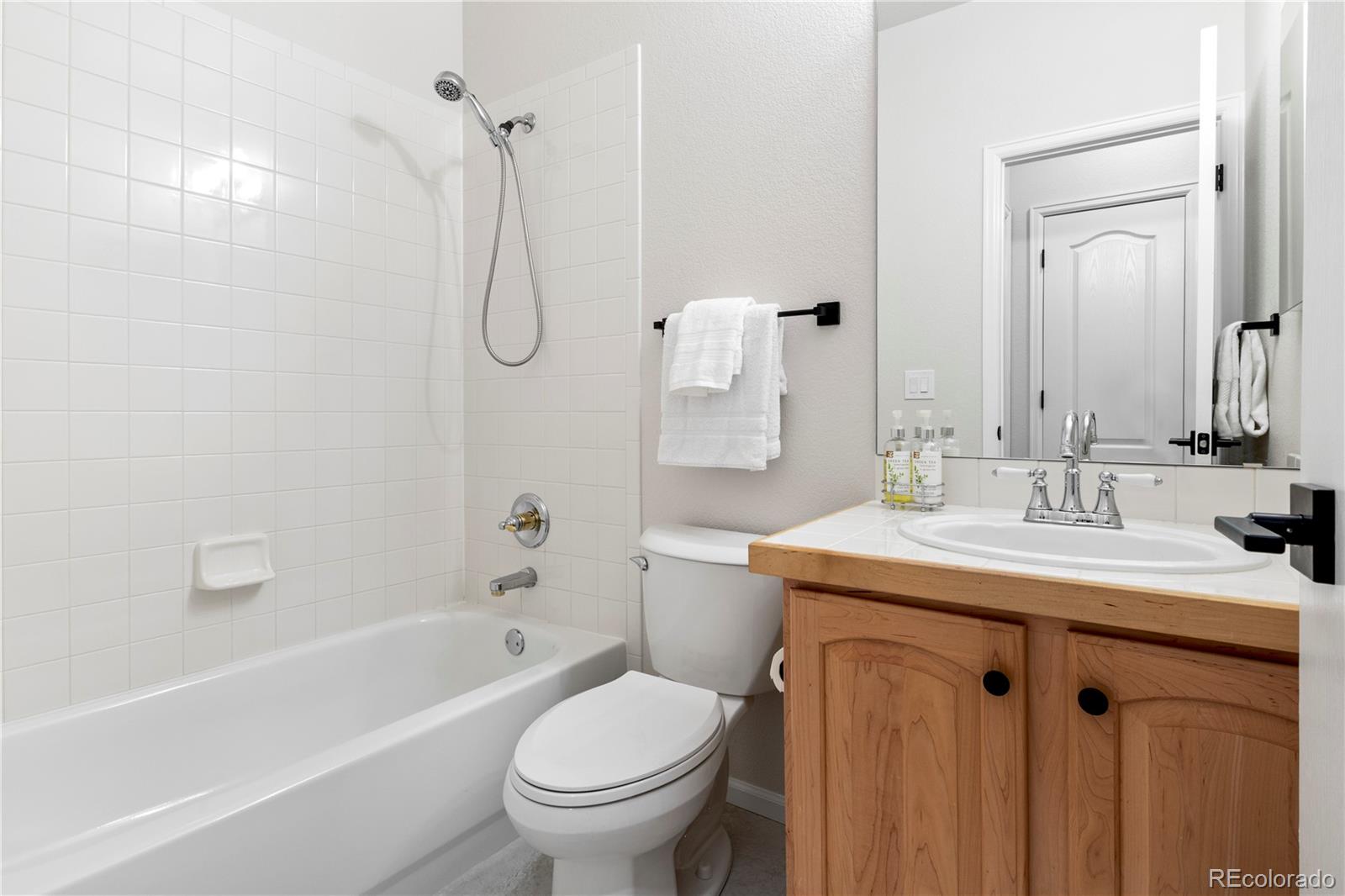 6900 West Grant Ranch Boulevard, Unit 53 Littleton, CO 80123 - Photo 20 of 31 a bathroom with a granite countertop sink toilet and shower