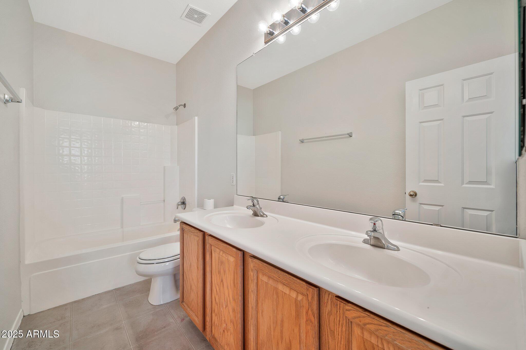 9437 West Berkeley Road Phoenix, AZ 85037 - Photo 12 of 21 a bathroom with a double vanity sink toilet and a mirror