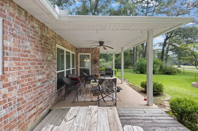 a view of a patio with table and chairs potted plants with wooden floor and fence