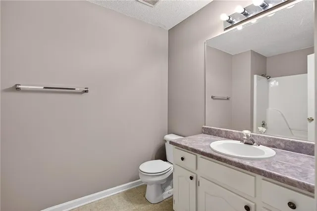a bathroom with a granite countertop sink toilet and a mirror