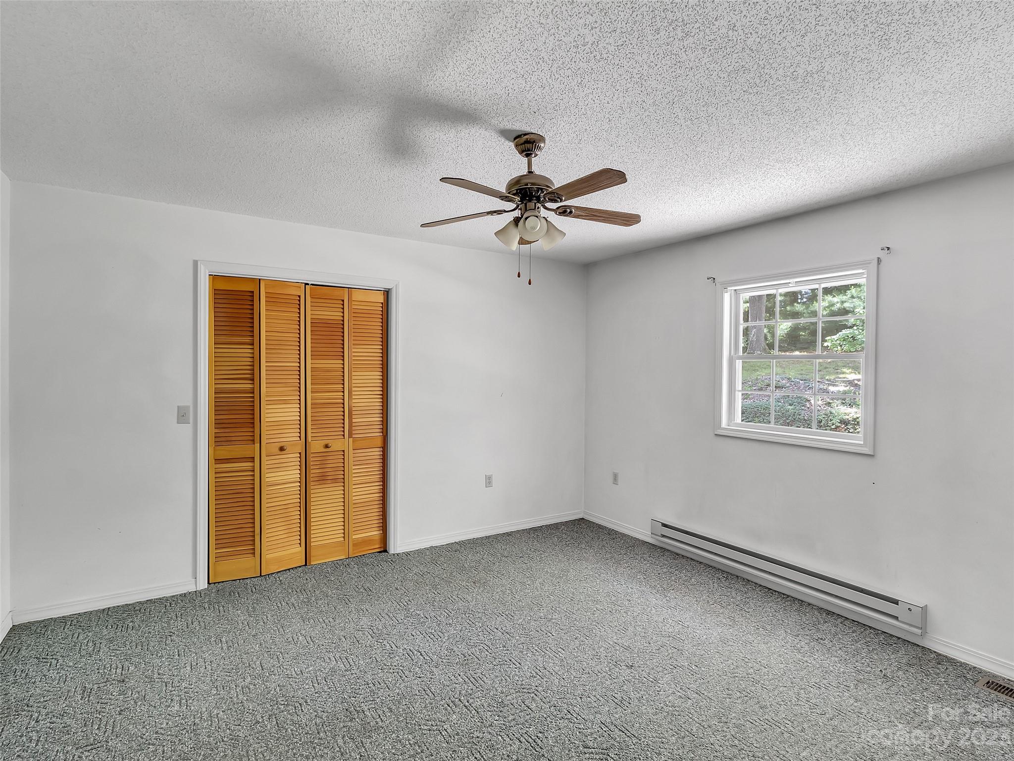 799 Nellie John Drive Clyde, NC 28721 - Photo 25 of 38 an empty room with windows and fan
