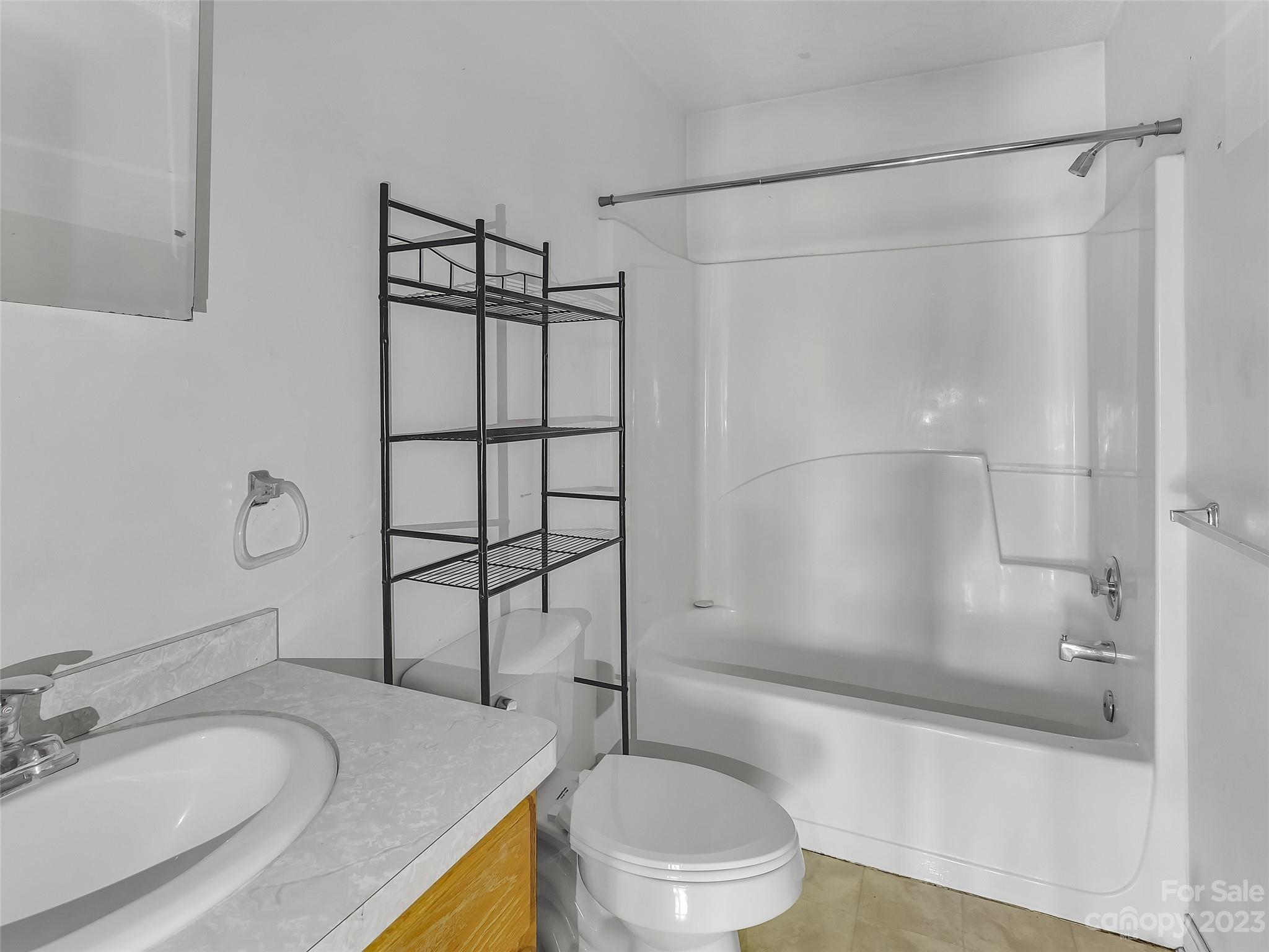 799 Nellie John Drive Clyde, NC 28721 - Photo 26 of 38 a bathroom with a granite countertop sink toilet and shower
