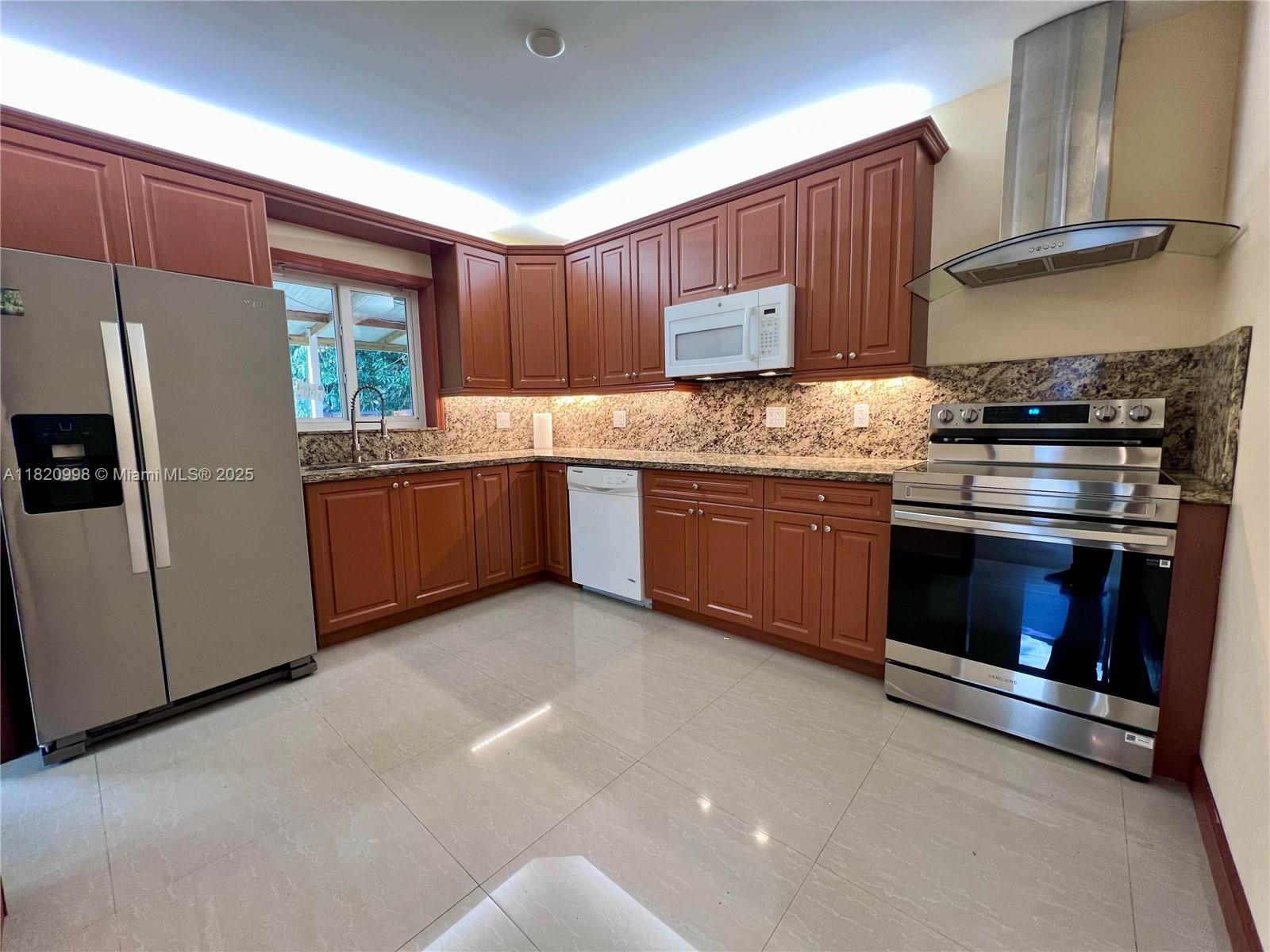 6225 Southwest 26th Street Miami, FL 33175 - Photo 5 of 10 a kitchen with granite countertop stainless steel appliances and wooden cabinets