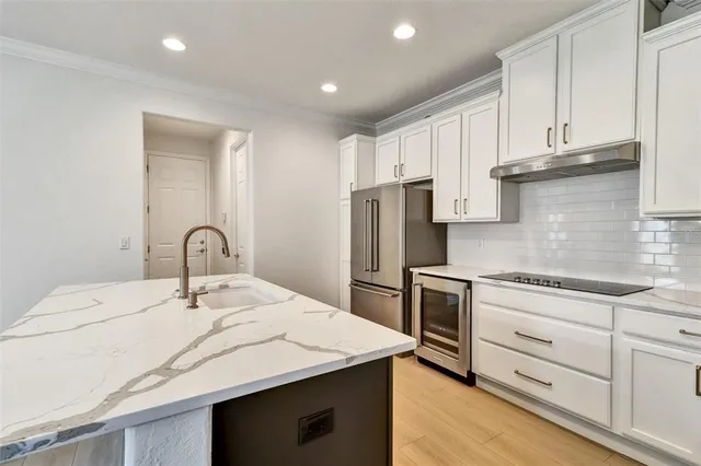 a kitchen with white cabinets sink and stainless steel appliances