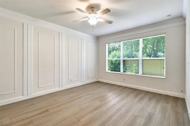 a view of an empty room with a window and wooden floor