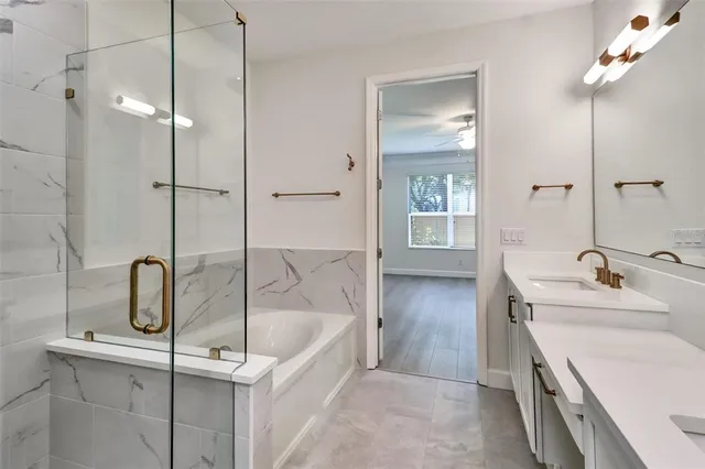 a bathroom with a tub sink and mirror