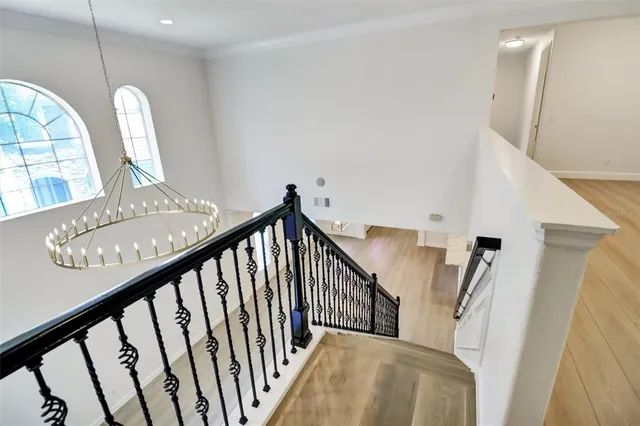 a view of staircase with railing and white walls