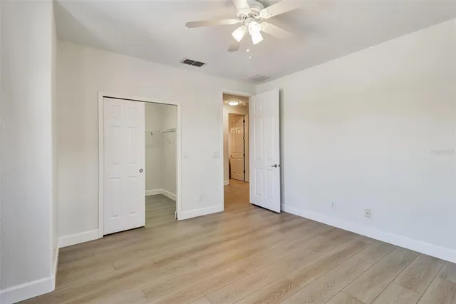 an empty room with wooden floor and closet area