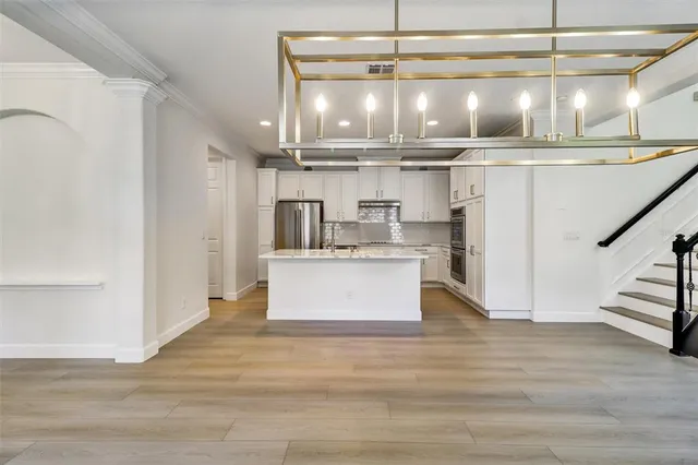 a kitchen with kitchen island a counter top a stove and cabinets