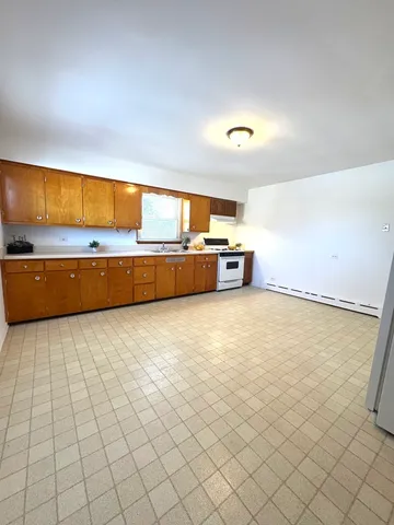 a view of kitchen and empty room