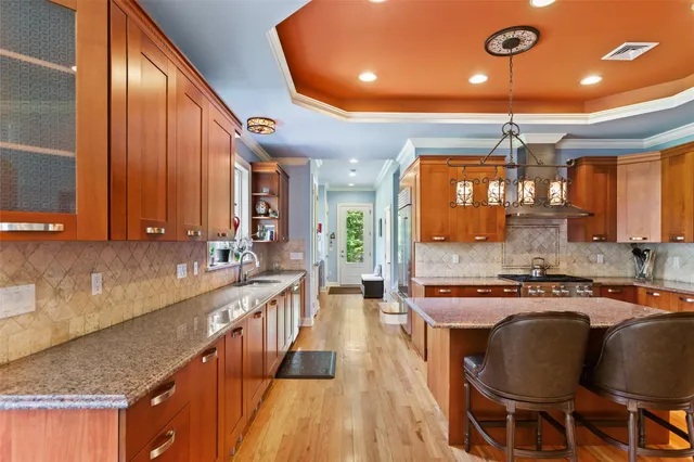 a kitchen with stainless steel appliances granite countertop a stove a sink dishwasher and cabinets with wooden floor