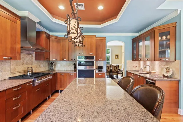 a large kitchen with kitchen island granite countertop a large window and stainless steel appliances